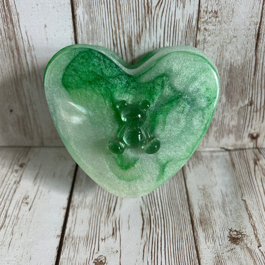 Green heart-shaped jewelry box on a wooden surface