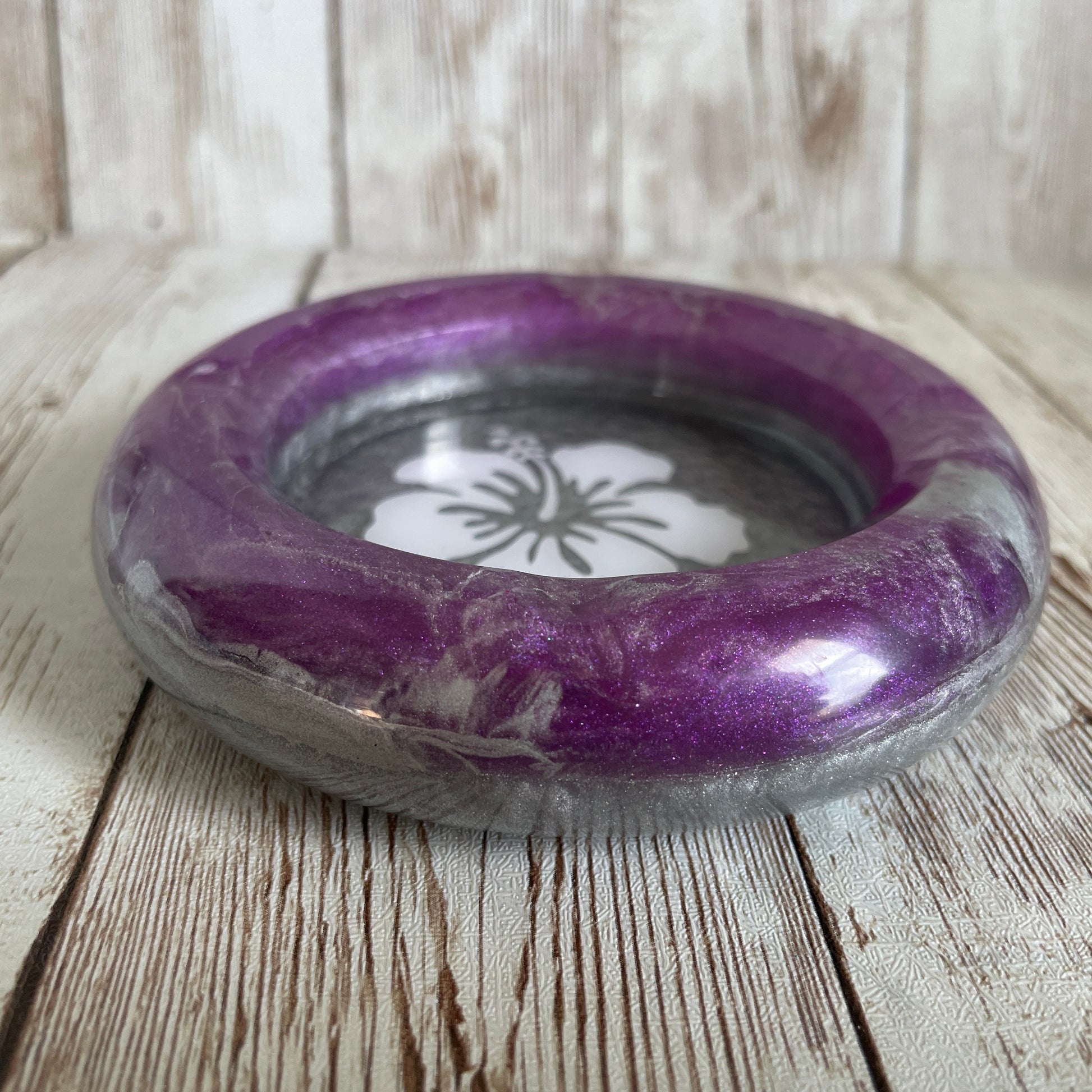 Purple and gray ashtray on a wooden surface